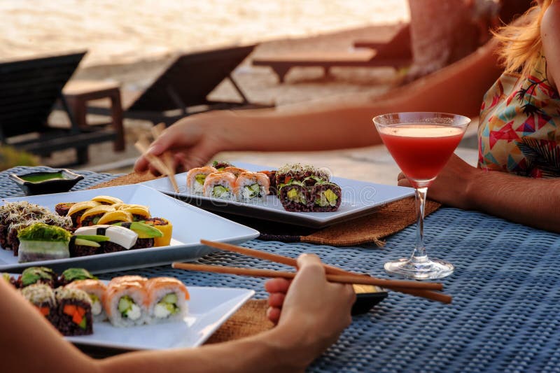 The Dinner with Japanese Sushi at the Beach on the Sunset Stock Photo