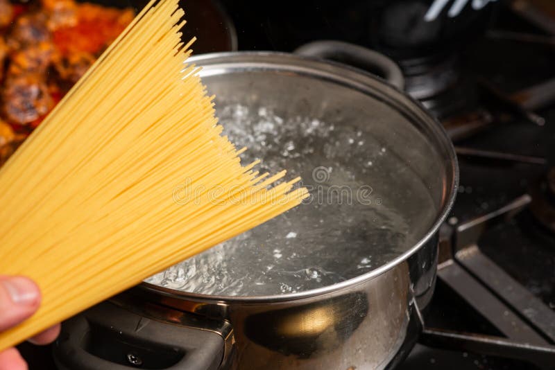 Dip Spaghetti into Boiling Water in a Saucepan. Pasta Cooking Stock
