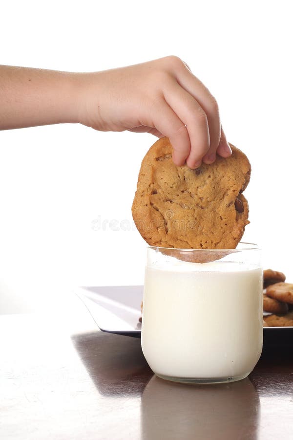Dipping cookie in milk vertical