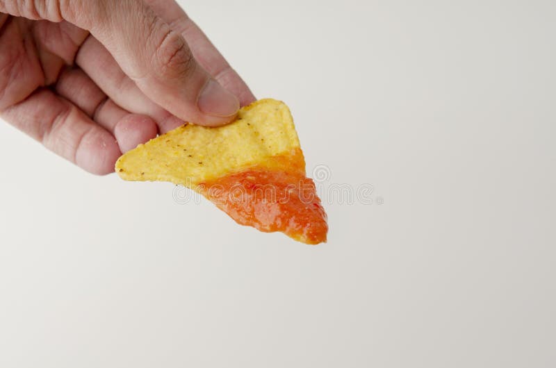 Dipping Tortilla Chips with Salsa Sauce in Dish on White Background