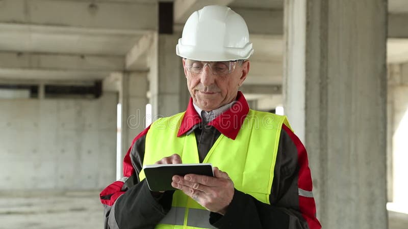 Directeur des travaux avec l'appareil électronique au chantier de construction