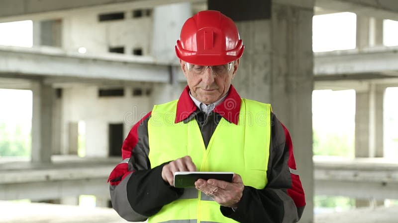 Directeur des travaux avec l'appareil électronique au chantier de construction