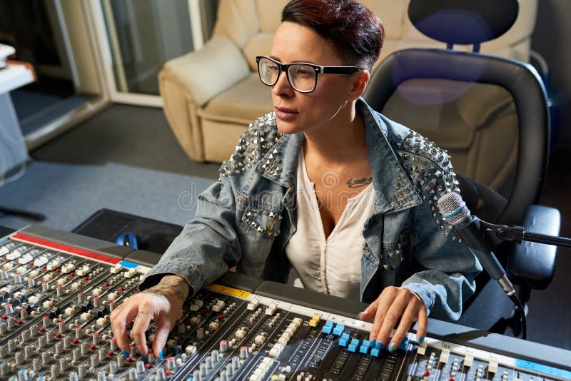Directeur sain songeur employant le mélangeur audio dans le studio image libre de droits Directeur sain songeur employant le mélangeur audio dans le studio image libre de droits