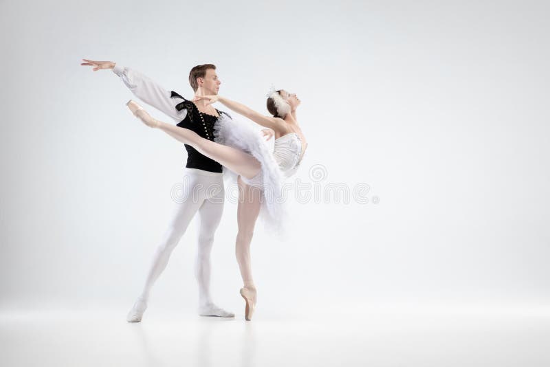 Young graceful couple of ballet dancers on white studio background. Direction. Graceful classic ballet dancers dancing isolated on white studio background stock photo Young graceful couple of ballet dancers on white studio background. Direction. Graceful classic ballet dancers dancing isolated on white studio background stock photo