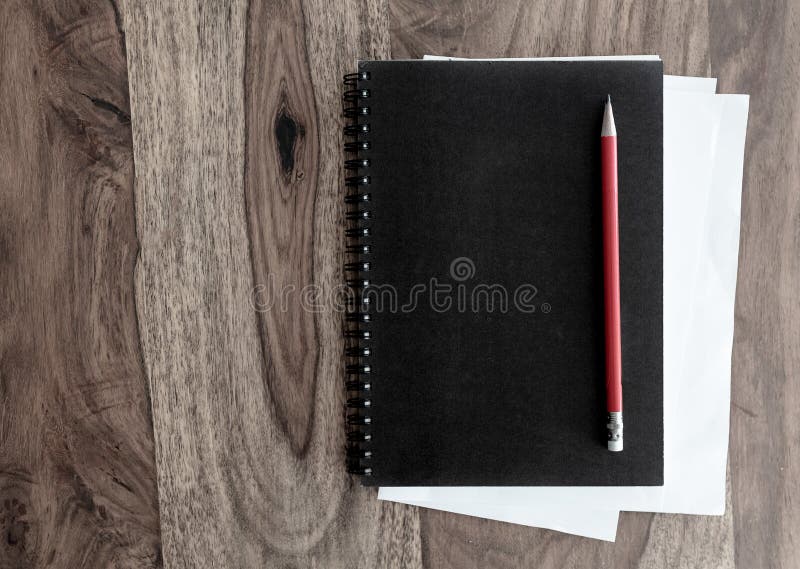 Black spiral notebook and pen on wooden table stock image Black spiral notebook and pen on wooden table stock image