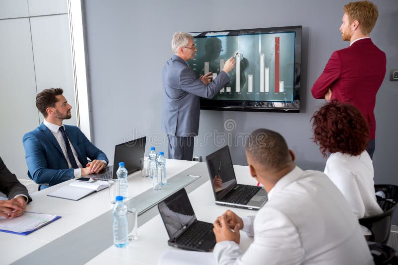 Direktören analyserar statistik på ett möte royaltyfri bild