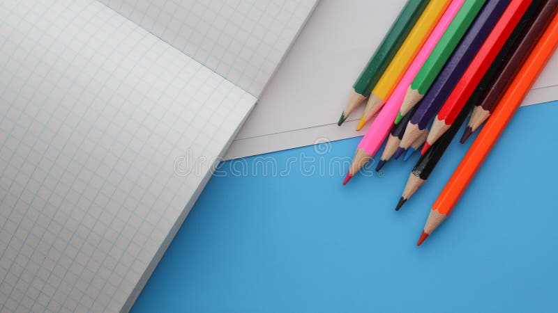 Diretamente acima do tiro de lápis coloridos por livros no fundo azul