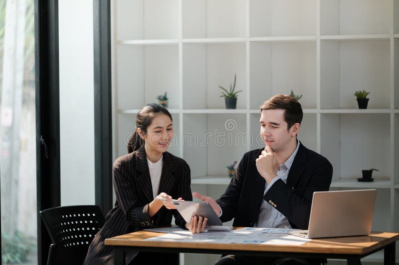 Direttore generale e direttore generale dell'azienda parlano con un computer portatile in ufficio. brainstorming di due profession. brainstorming, due professionisti di successo, trova una soluzione alla propria strategia di investimento software di e-commerce. foto di alta qualità.
