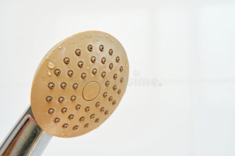 Dirty corroded limescale calcified old shower head hanging from a stand inside cabin royalty free stock image