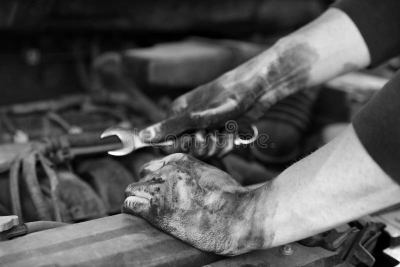 Dirty mechanic fixing car, closeup. Black and white effect