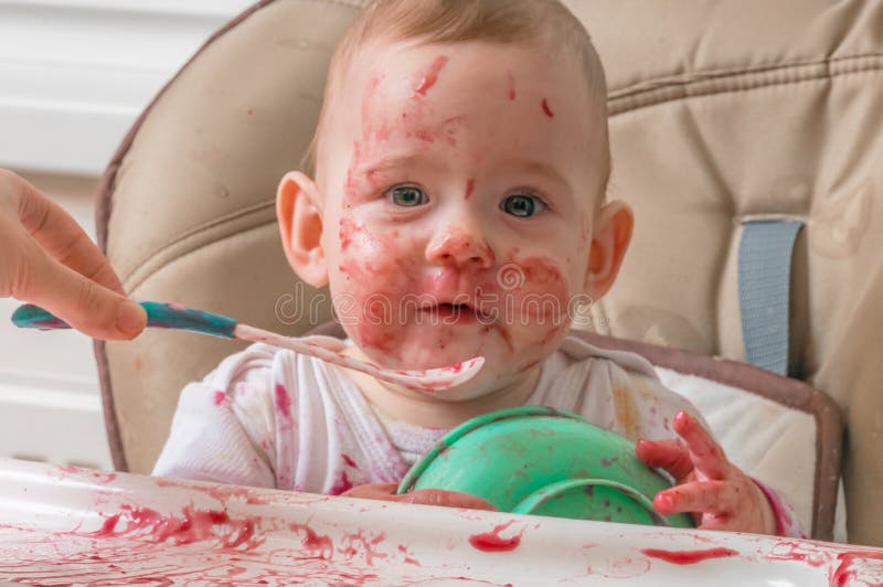 Dirty and messy baby is eating from bowl royalty free stock photo