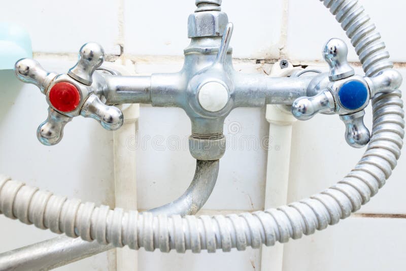 Dirty old faucet with limescale or lime scale on it, dirty calcified and rusty shower mixer tap and hose, moldy tiles on royalty free stock photo