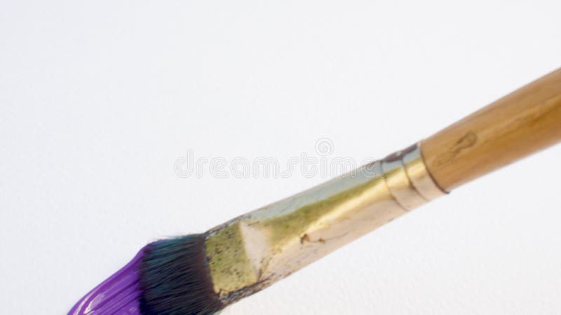 Dirty paintbrush drawing purple line with acrylic paint on textured paper, close up smear on canvas, abstract background