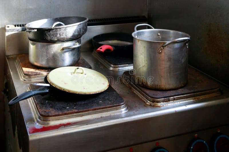 Dirty pots and pans are placed on a stainless steel electric stove on the galley on the ship