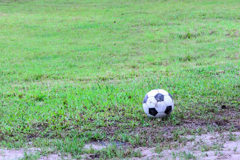 Dirty soccer ball in wet field