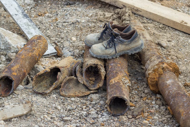 Dirty work boots on old pipes