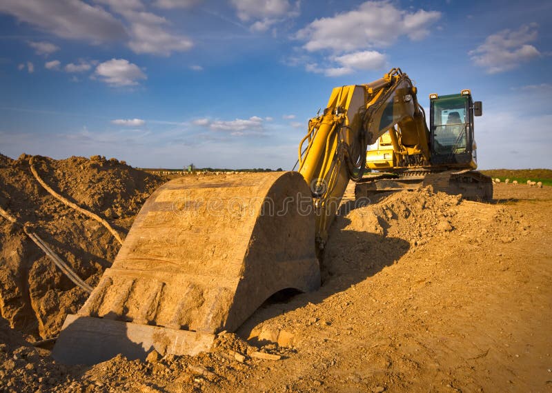 Yellow excavator levels its bucket of sand, earth, clay, Stock Photo,  Picture And Low Budget Royalty Free Image. Pic. ESY-058997993