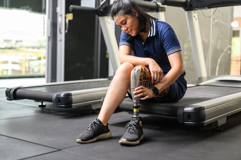 Disabled Athlete Patient with Prosthetic Leg Doing Exercise at Gym