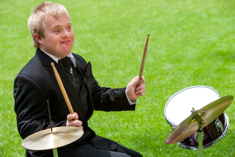 Handicapped drummer boy playing drums outdoors. Handicapped drummer boy playing drums outdoors.