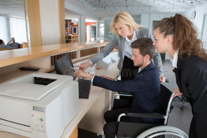 Disabled Businessman in Wheelchair Working at Reception Stock Photo