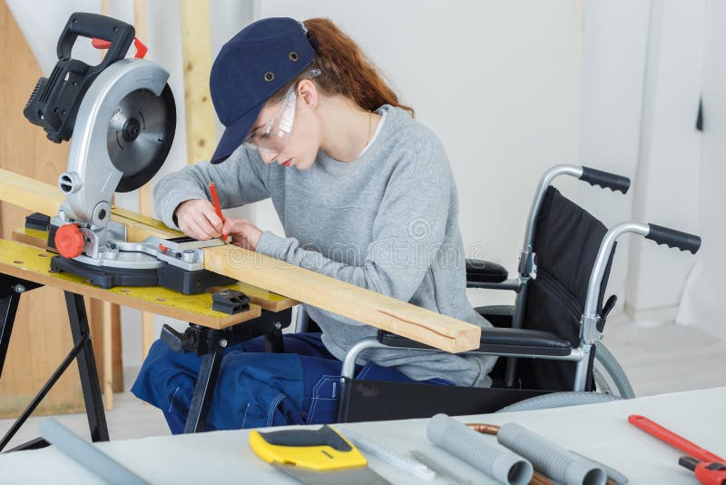 Disabled female worker in wheelchair in carpenters workshop