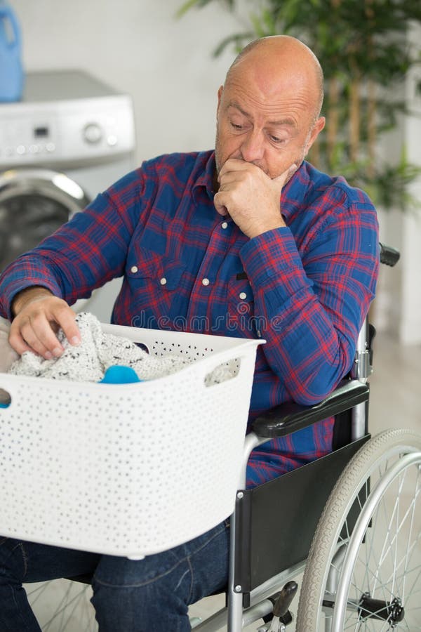 Disabled Man Looking through Basket Laundry with Confusion Stock Image