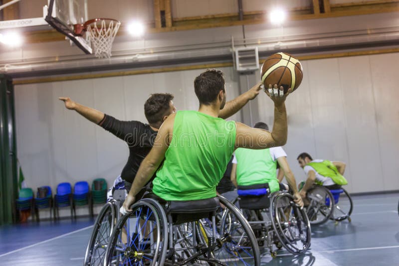 Disabled sport men in action while playing indoor basketball