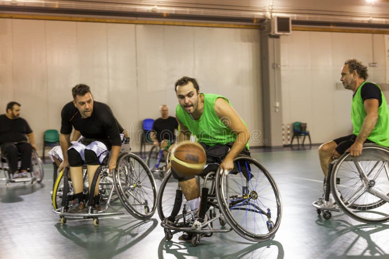 Disabled sport men in action while playing indoor basketball