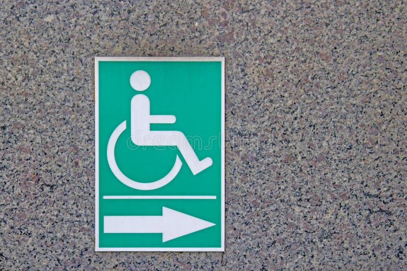 Disabled symbol On the green Stick to the marble walls stock image