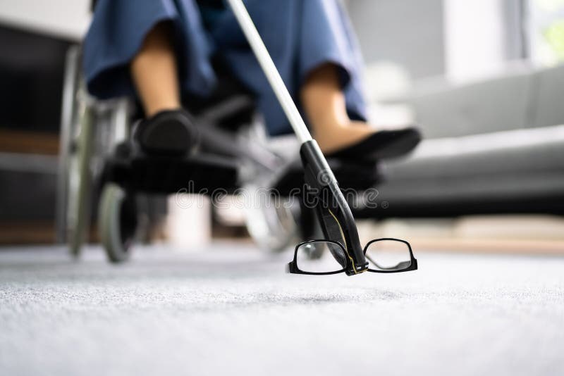 Disabled Woman In Wheelchair Using Grabber Tool Or Reacher. For Fallen Glasses royalty free stock image