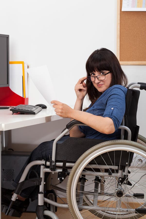 Disabled Young Girl on Wheelchair Working in Her Office Stock Image