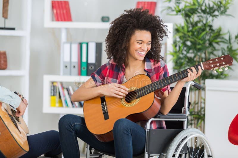 disabled young woman playing guitar at home