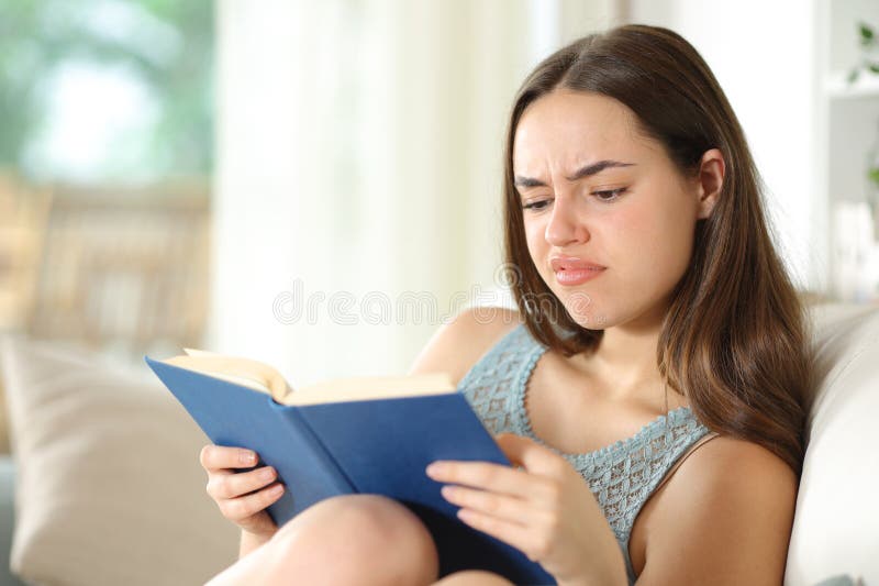 Disappointed woman reads a paper book in a house royalty free stock photos