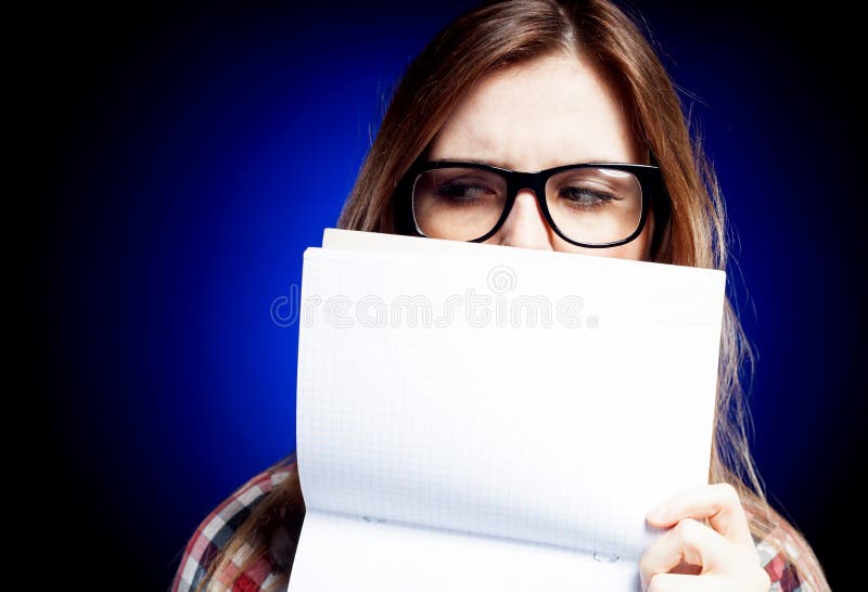 Disappointed young girl with nerd glasses holding