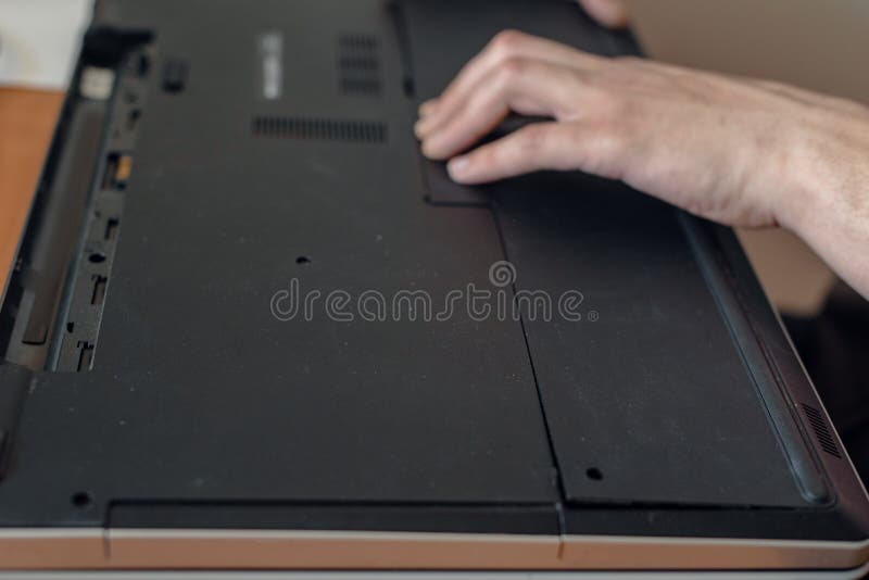 Disassembling a Laptop. Men S Hands with a Plastic Card Removes the