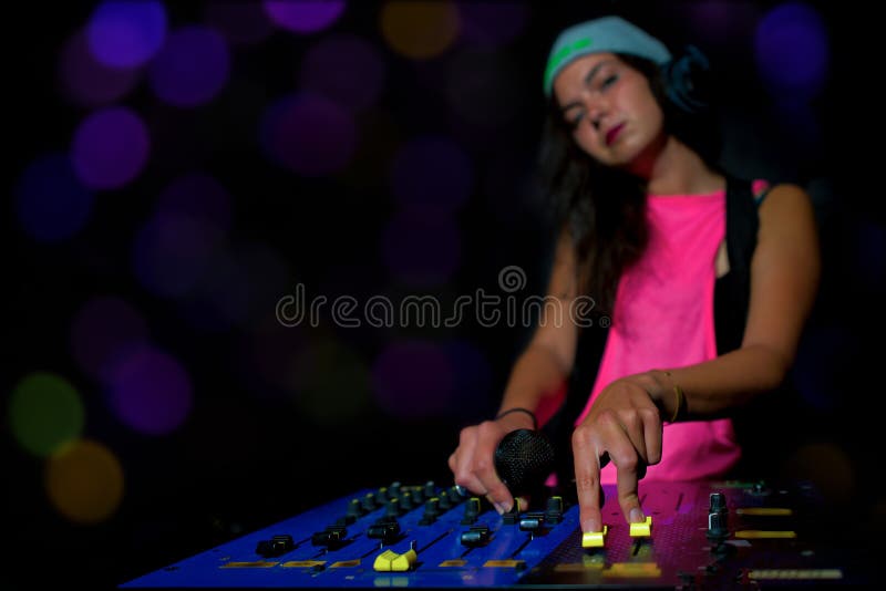 Disc-jockey fascinant de fille au bruit de mélange de travail sur sa console à un p photo stock Disc-jockey fascinant de fille au bruit de mélange de travail sur sa console à un p photo stock