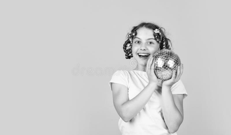 Discoteca. peluquería. jocoso. peinado para una fiesta disco. divertirse. niño sostiene bola de disco dorada. retro fotos de archivo libres de regalías