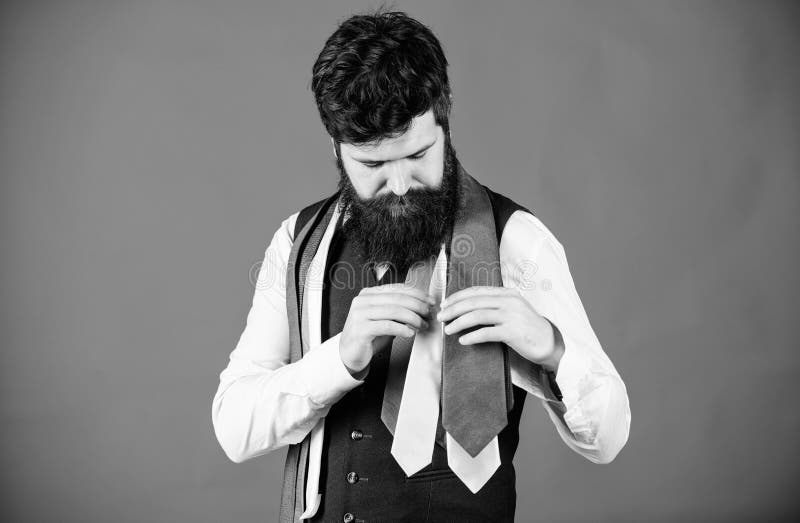 Discover trendy mens fashion in our shop. Bearded man choosing luxury necktie in menswear shop. Shop assistant offering wide choice of finest neckties. Shop for mens clothes and accessories.