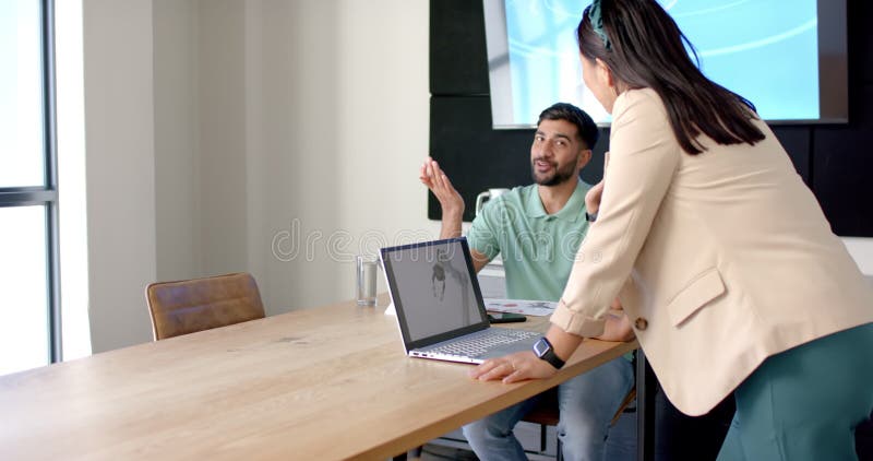 Discussing project, colleagues using laptop with robotic design in modern office, copy space stock footage