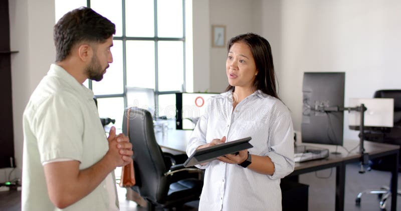 Discussing project details, colleagues in modern office with tablet and computer screens stock footage