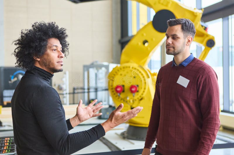 Discussion about robotics development and programming in a modern industrial environment stock photography
