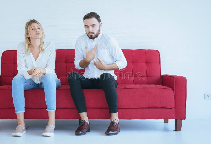 Discussão do marido com conflito da esposa e pares furando na sala de visitas, emoções negativas imagens de stock Discussão do marido com conflito da esposa e pares furando na sala de visitas, emoções negativas imagens de stock