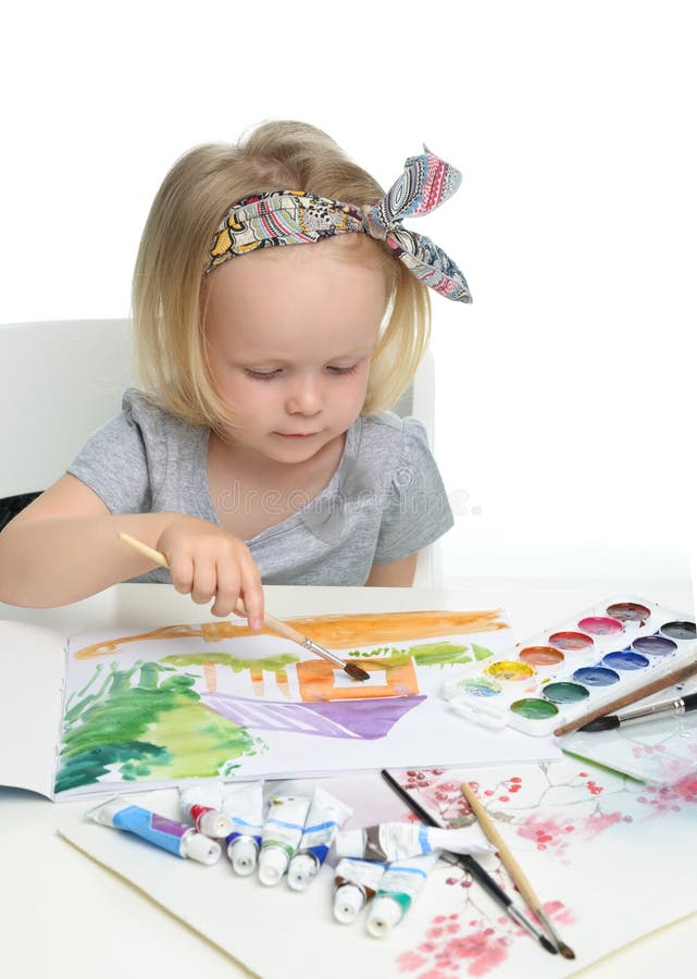 Disegno allegro felice del bambino della neonata con la spazzola in album con immagine stock Disegno allegro felice del bambino della neonata con la spazzola in album con immagine stock