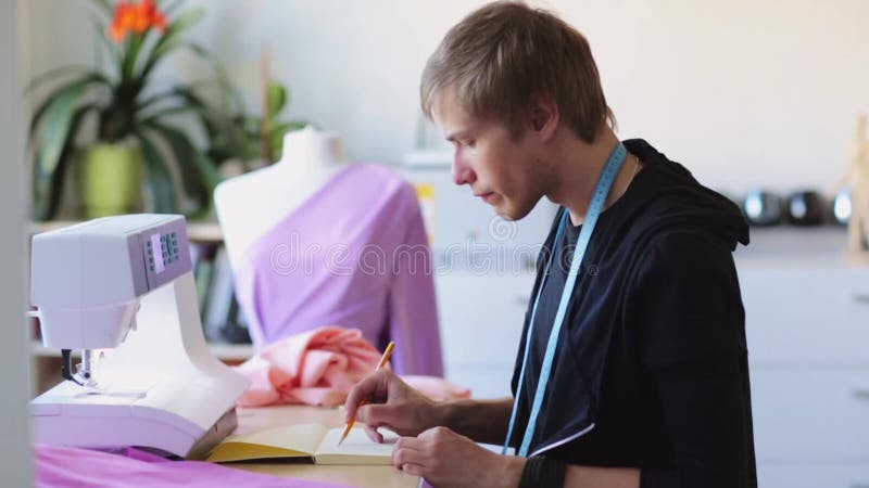 Diseñador de moda con el dibujo del cuaderno en el estudio