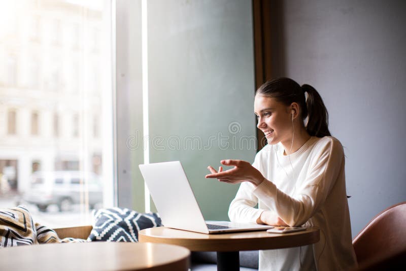 Diseñador de sexo femenino alegre que tiene presentación webinar o en línea vía el cuaderno fotos de archivo Diseñador de sexo femenino alegre que tiene presentación webinar o en línea vía el cuaderno fotos de archivo
