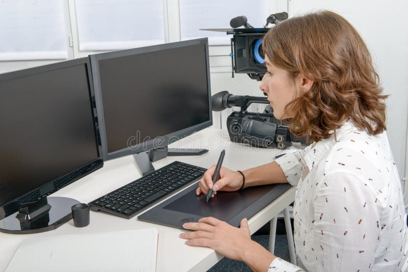 Diseñador de sexo femenino joven que usa la tableta de gráficos fotografía de archivo Diseñador de sexo femenino joven que usa la tableta de gráficos fotografía de archivo