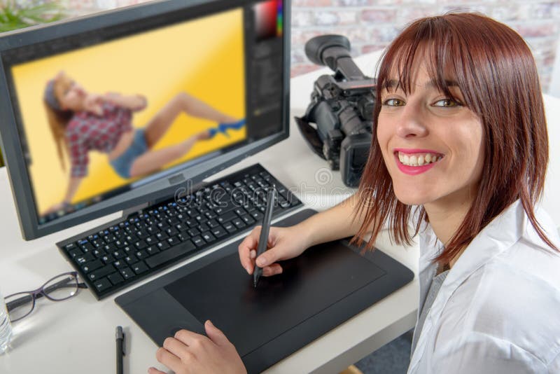 Diseñador de sexo femenino joven que usa la tableta de gráficos fotos de archivo Diseñador de sexo femenino joven que usa la tableta de gráficos fotos de archivo