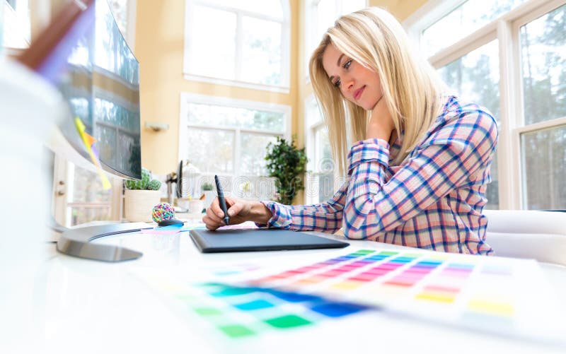 Graphic designer using her graphic tablet in an office. Graphic designer using her graphic tablet in an office