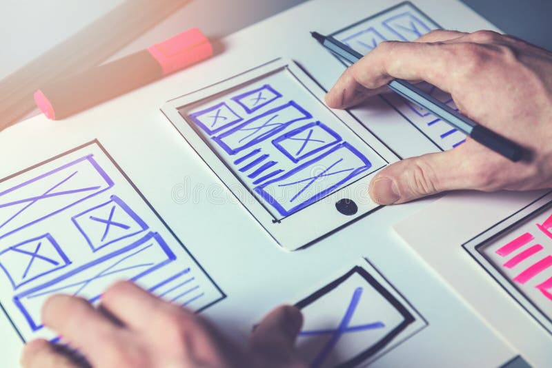 Ux graphic designer sketching wireframe for mobile app and website development project. Ux graphic designer sketching wireframe for mobile app and website development project