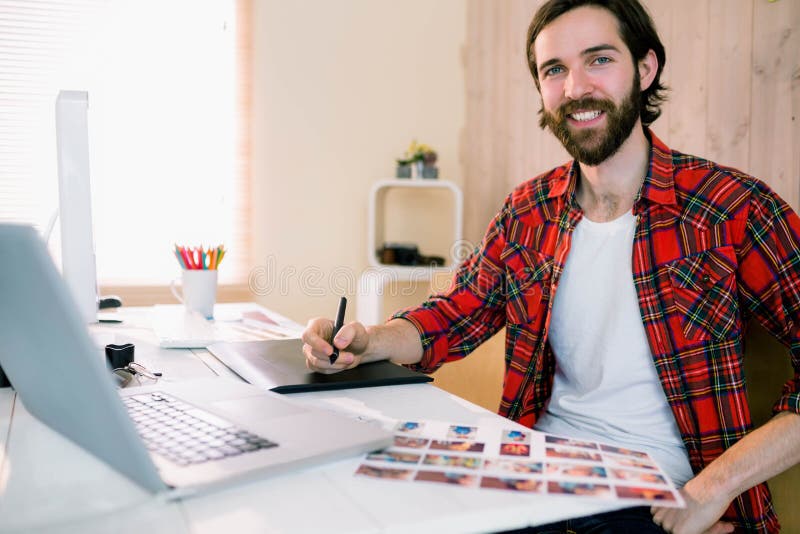 Diseñador hermoso que trabaja en su escritorio fotografía de archivo Diseñador hermoso que trabaja en su escritorio fotografía de archivo